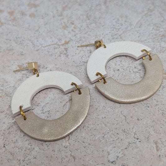 Pair of earrings with circular designs on a textured surface