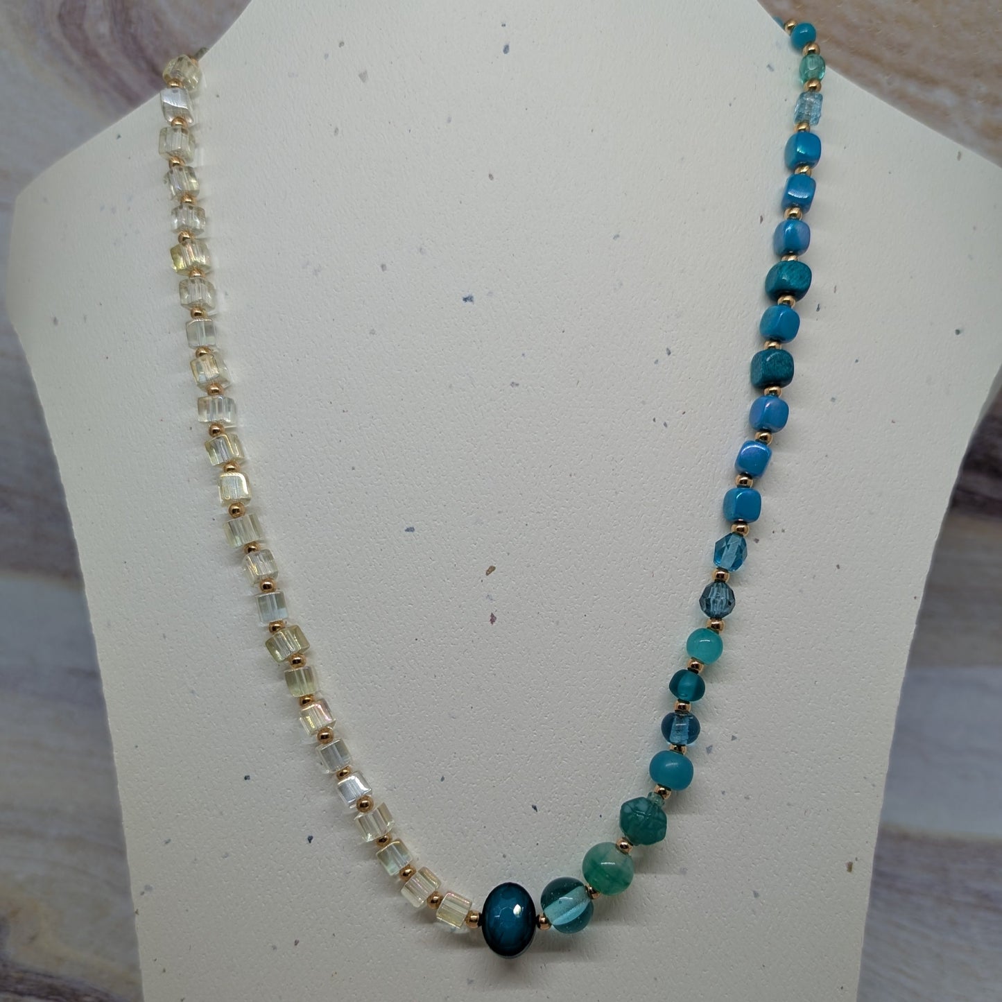 Beaded necklace on a mannequin bust with a neutral background