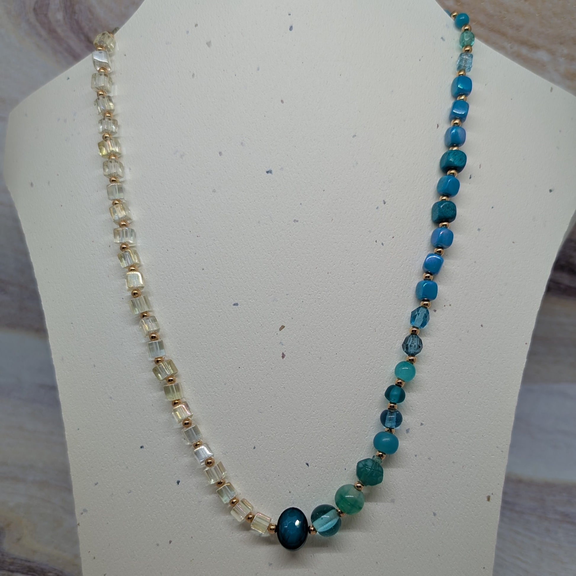 Beaded necklace on a mannequin bust with a neutral background