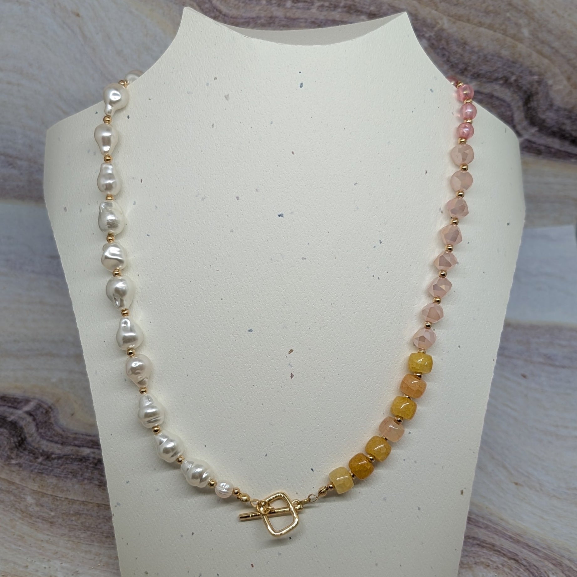 Necklace on a mannequin bust with a marbled stone background