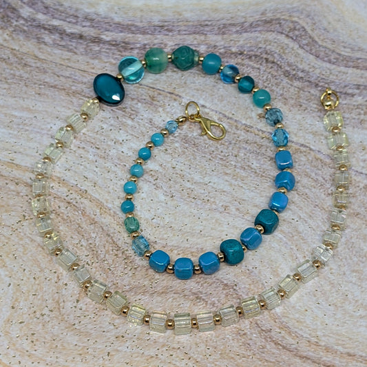 Beaded bracelet with blue and gold beads on a textured beige surface