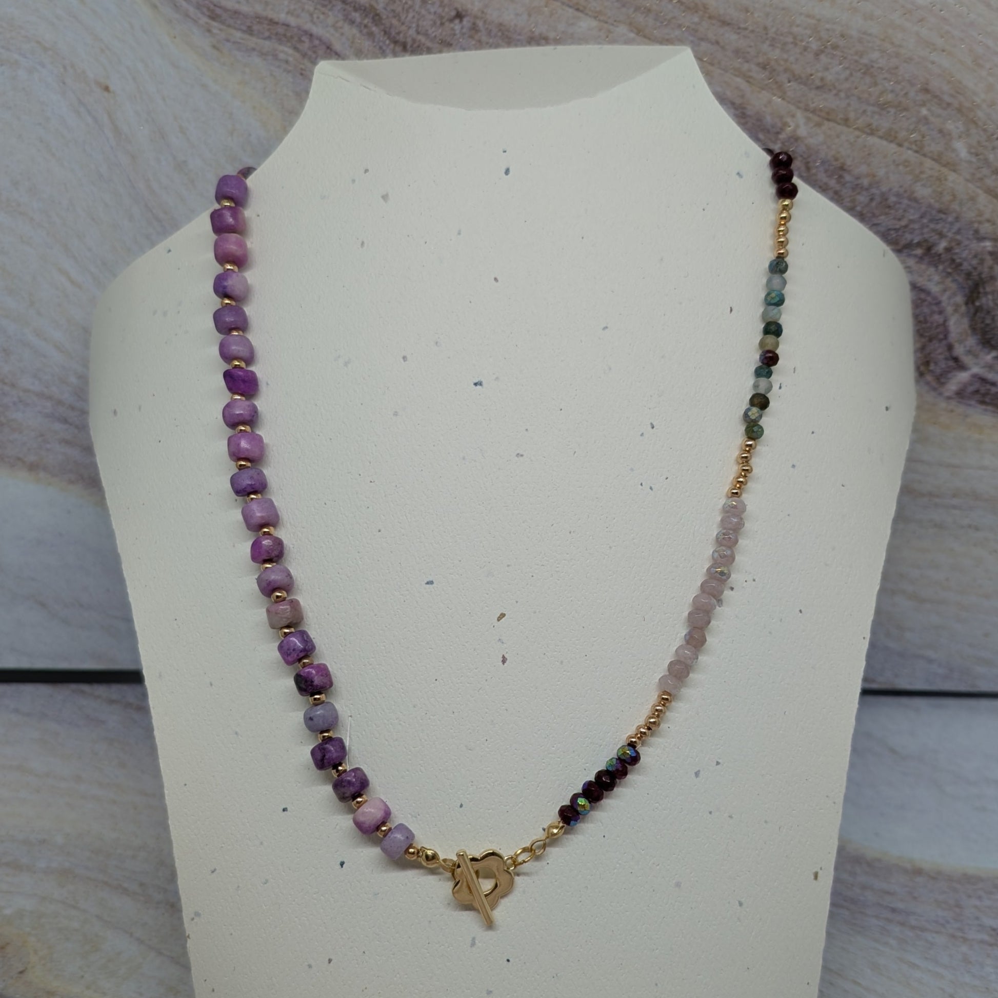 Beaded necklace on a mannequin bust with a marbled background
