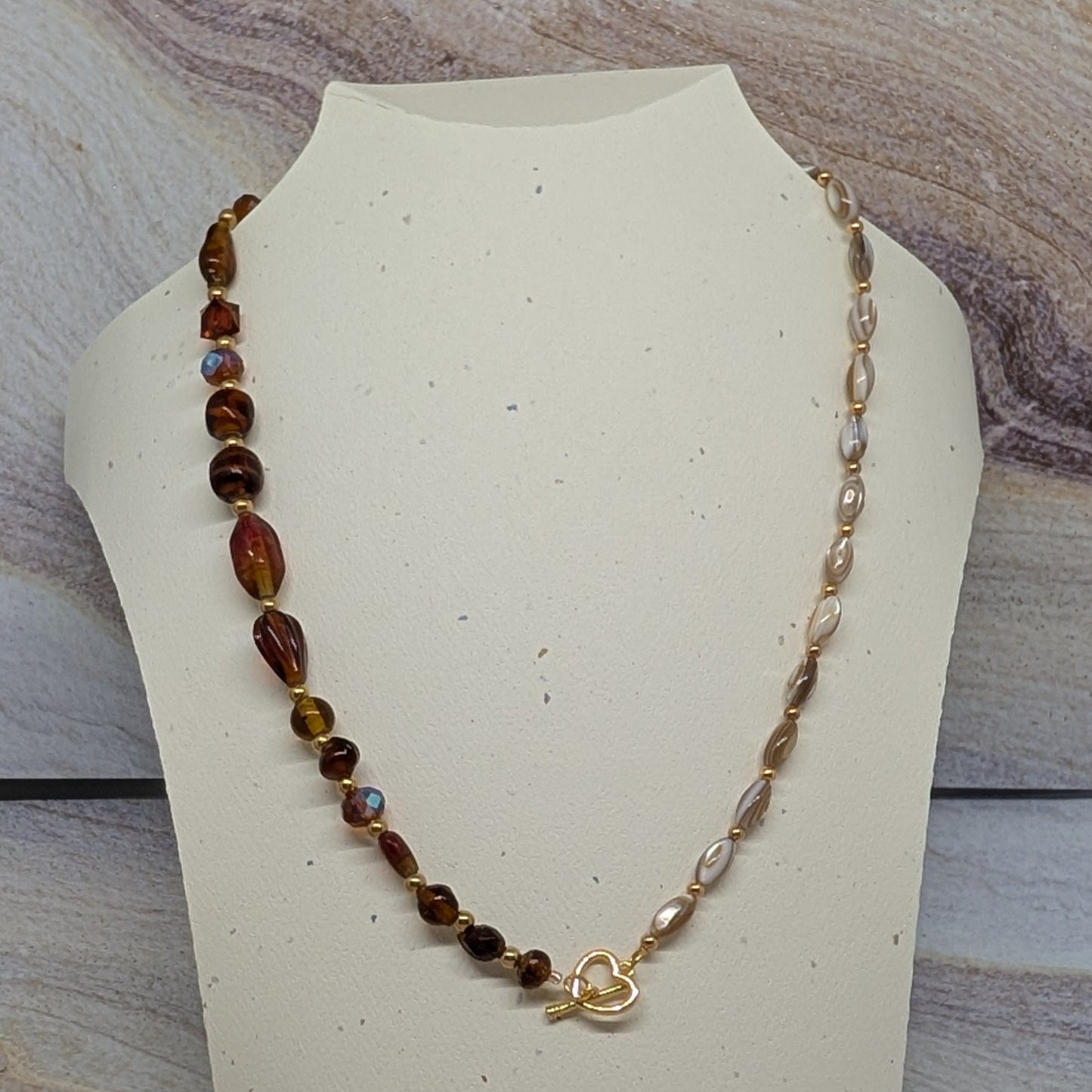 Necklace on a mannequin bust with a marbled background