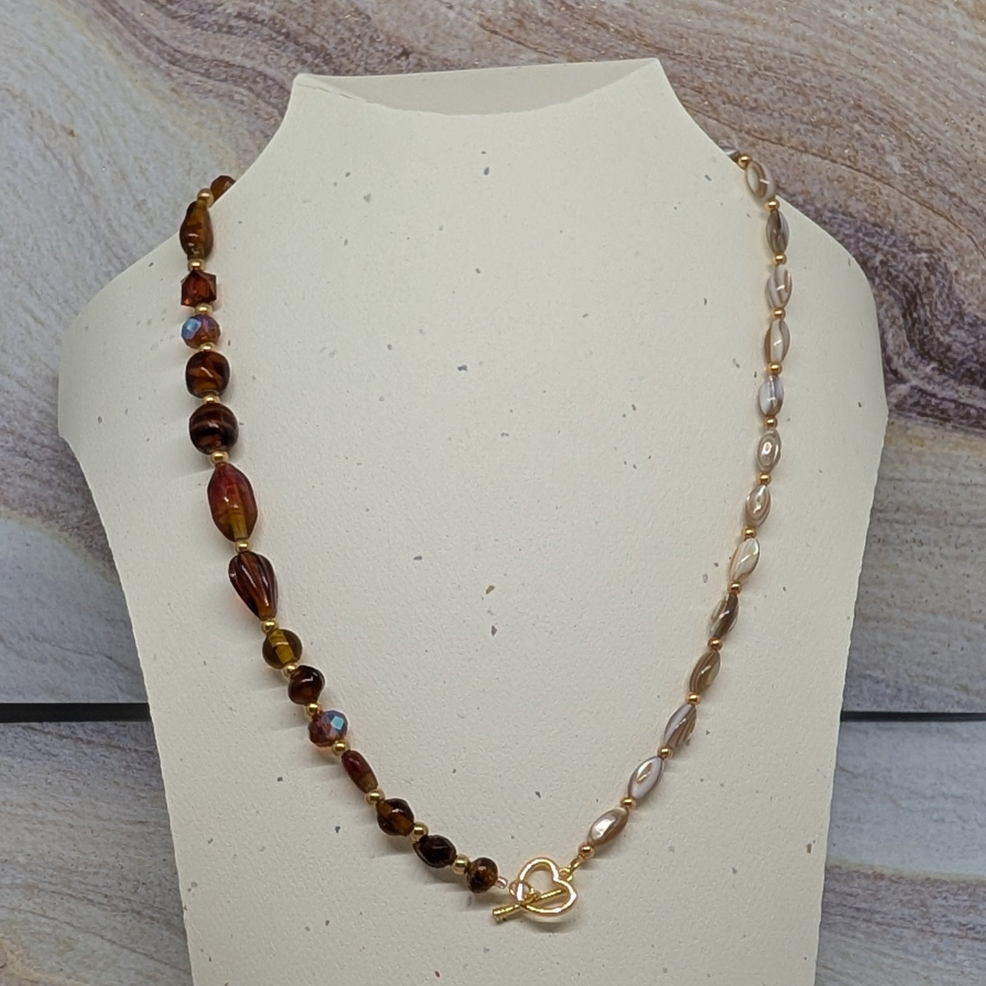 Necklace on a mannequin bust with a marbled background
