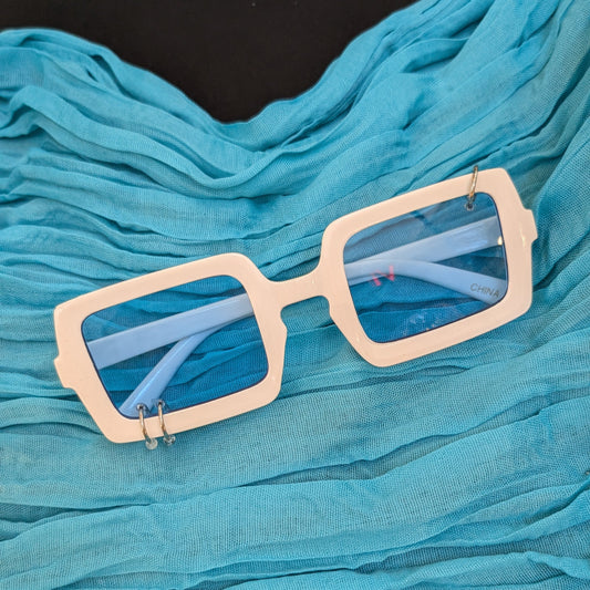 Beige sunglasses with reflective lenses on a blue fabric background