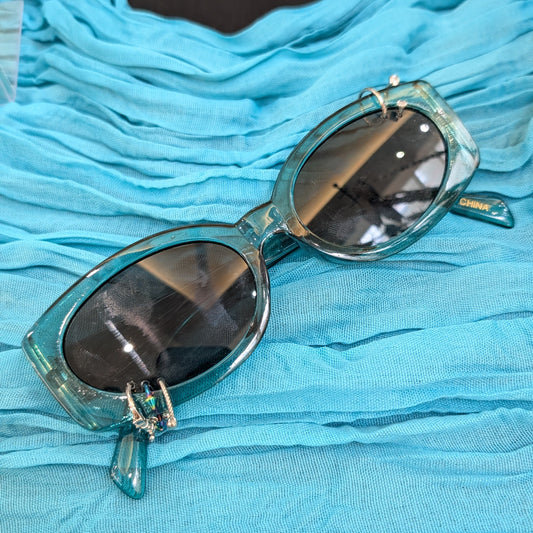 Sunglasses with turquoise frame on a blue fabric background