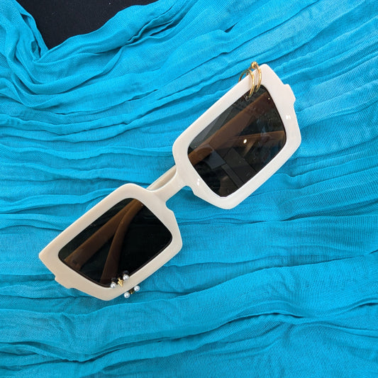 White sunglasses with black lenses on a blue textured surface