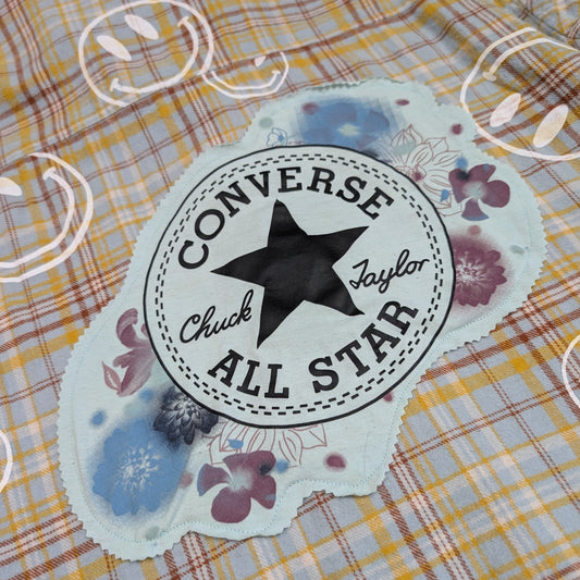 Converse All Star logo on a decorative background with floral elements