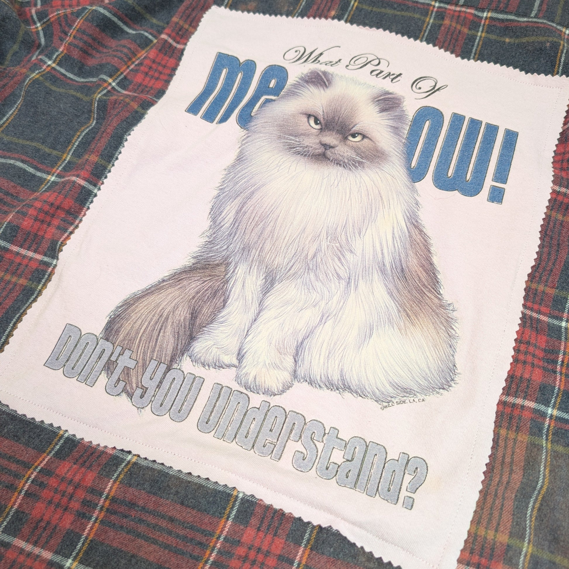 Plaid shirt with a cat graphic and text on a white background