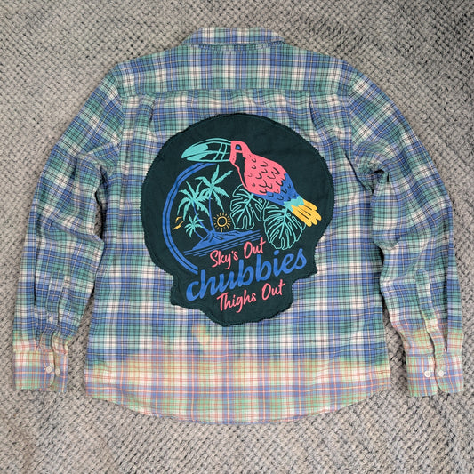Plaid shirt with a colorful graphic patch on a textured surface