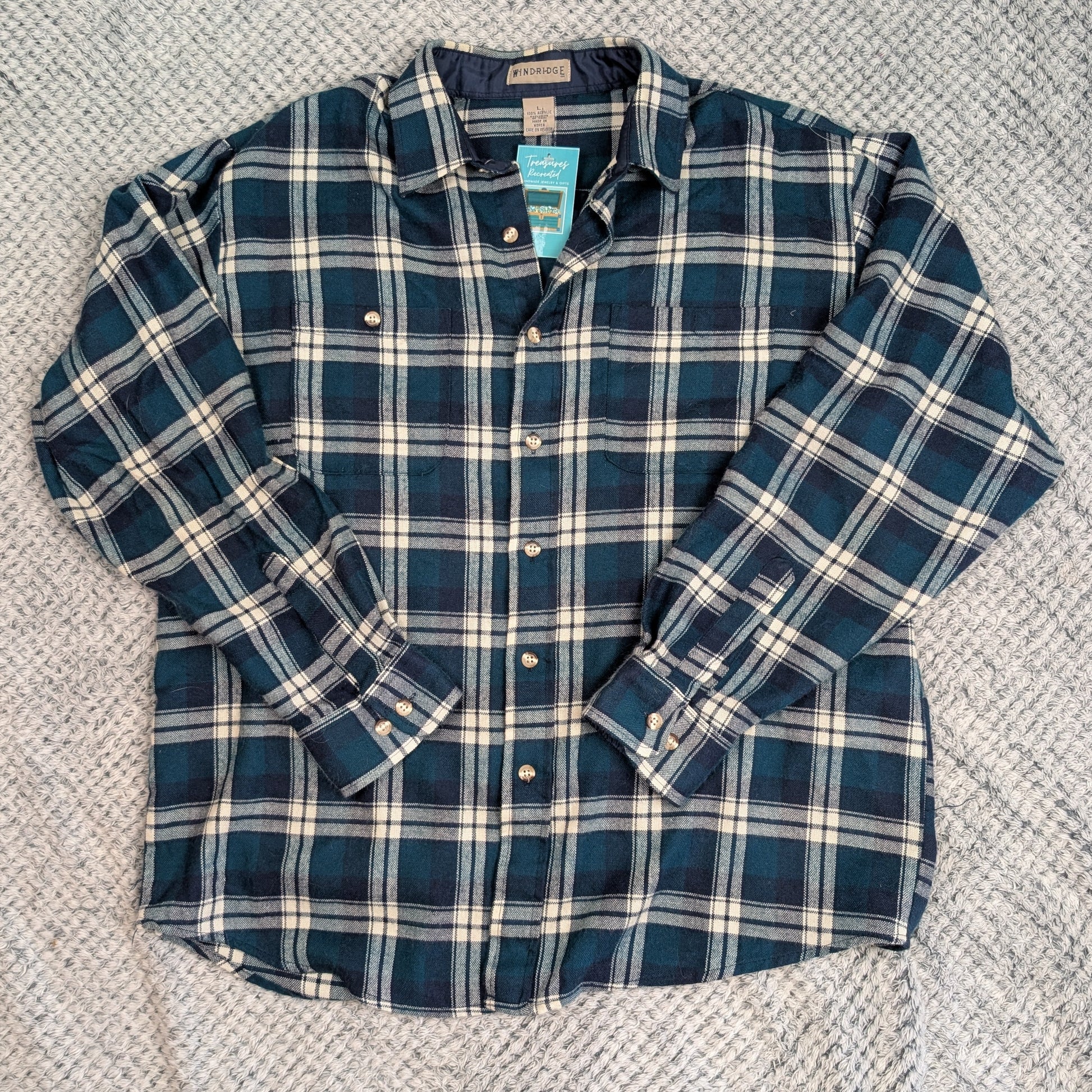 Blue and white plaid shirt on a textured gray surface
