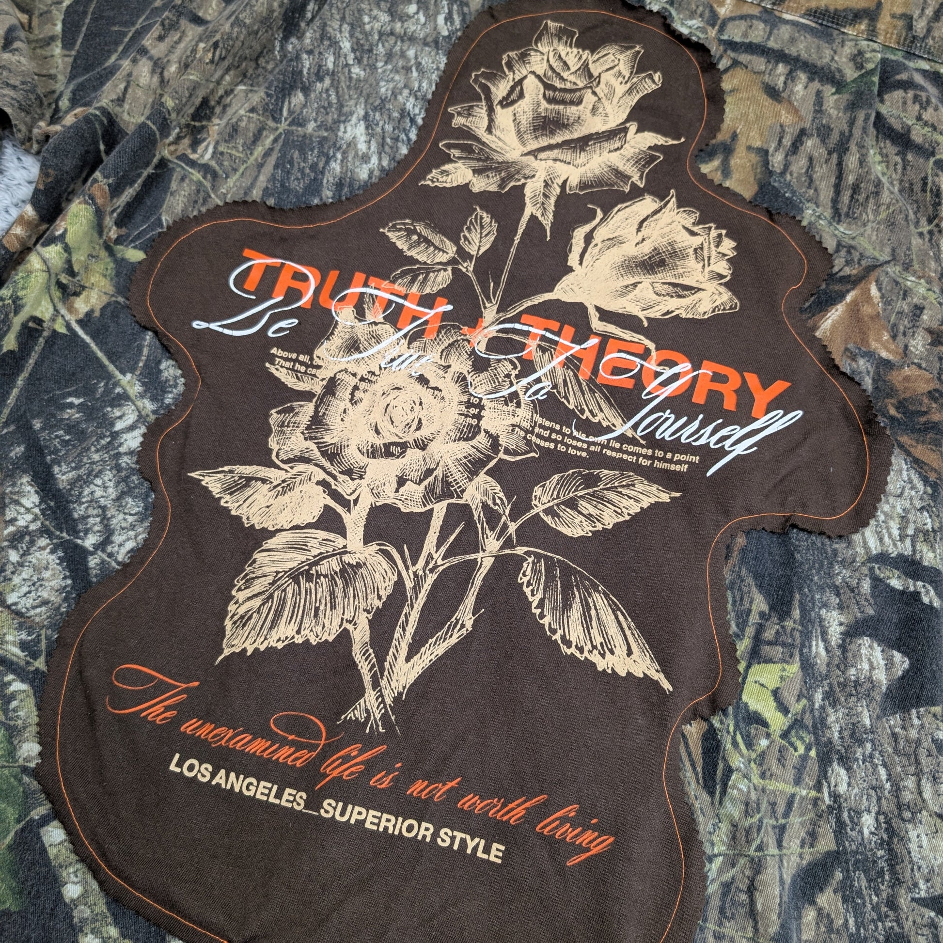 Patch with floral design and text on a camouflage background