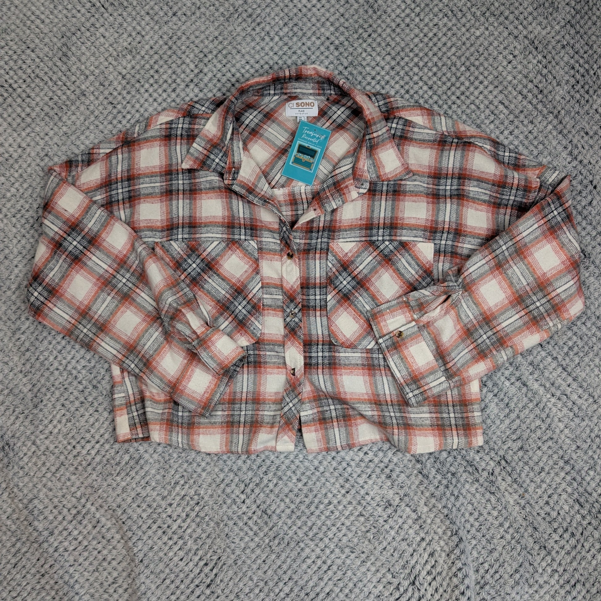 Plaid shirt with a tag on a textured gray surface