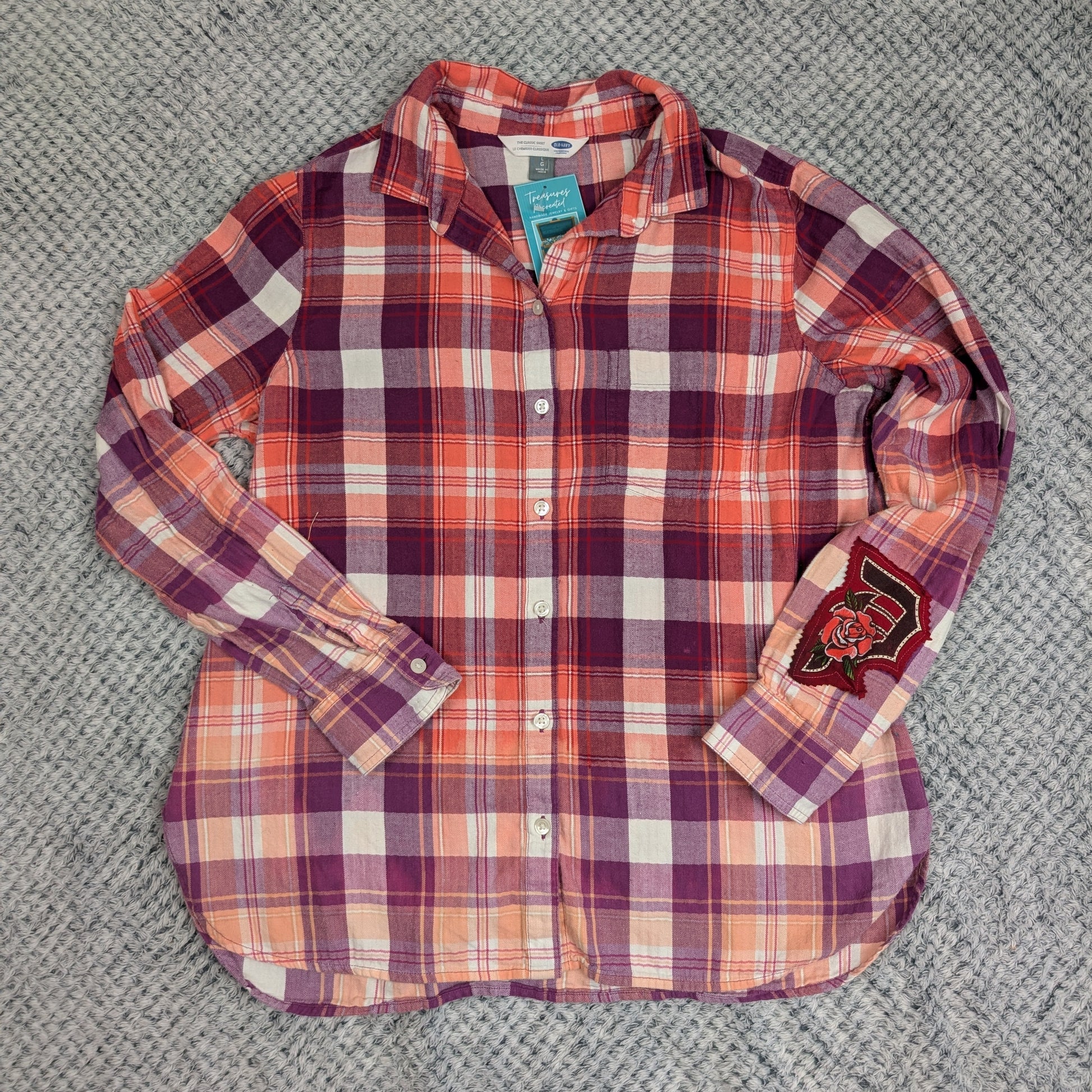 Plaid shirt with rolled-up sleeves on a textured gray surface