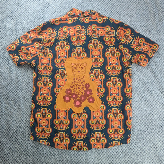 Short Sleeve button up shirt with bright orange graphic patterns. Featuring an orange and red cheetah graphic on a grey background. 